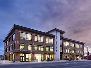 exterior view of a three-story building at dusk.