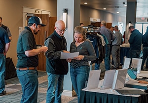 Three employee-owners discuss a paper.