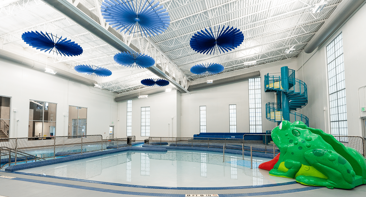The exposed ductwork in this photo was strategically routed through roof structure to effectively serve the natatorium and prevent condensation on exterior windows.