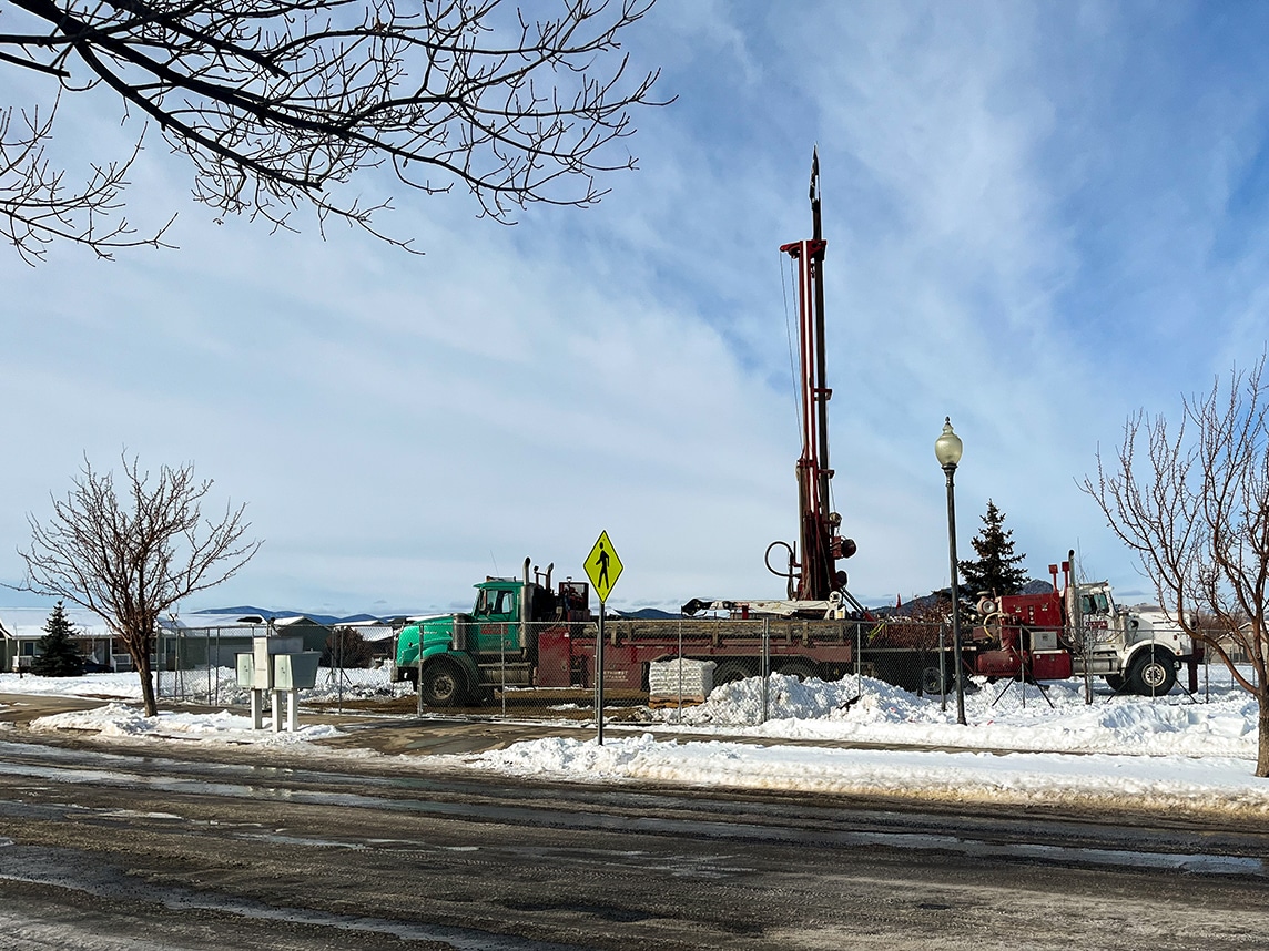 A drill rig with crane support truck.