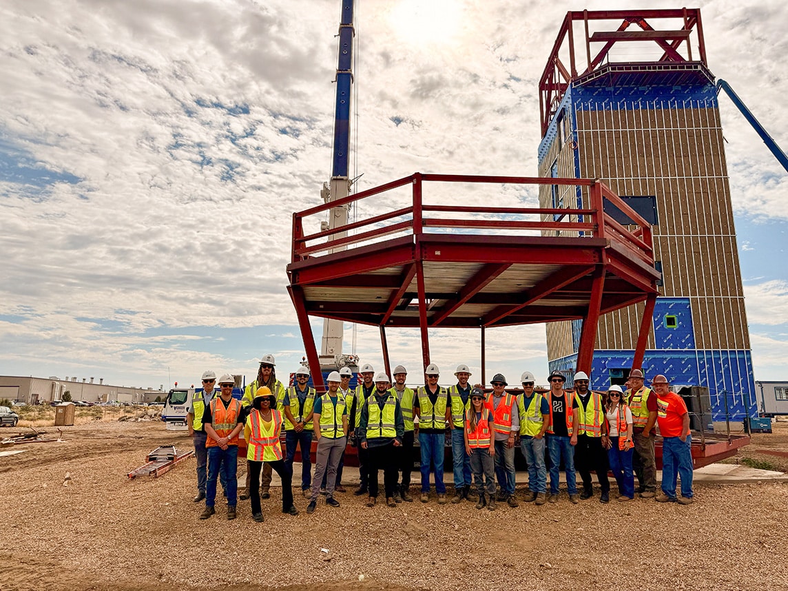 The project team poses in front of the cab framing. 